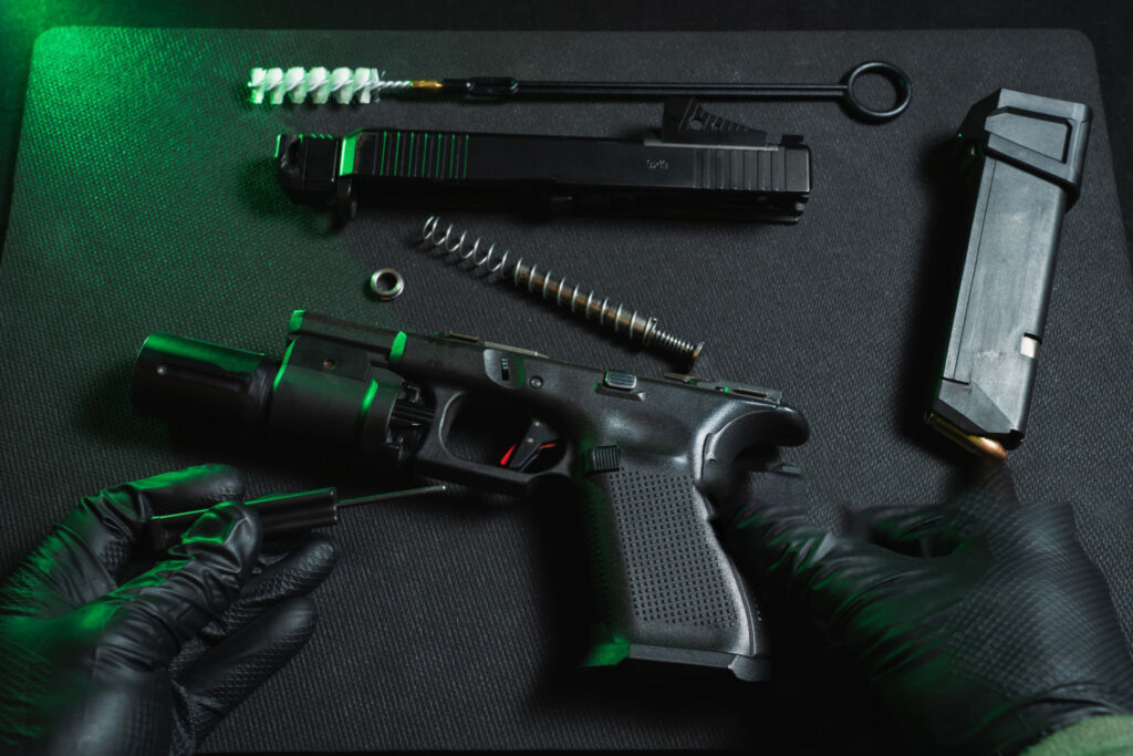 A high-resolution close-up of a Glock slide or pistol upper assembly placed on a dark table, with shallow depth of field and a tactical aesthetic.